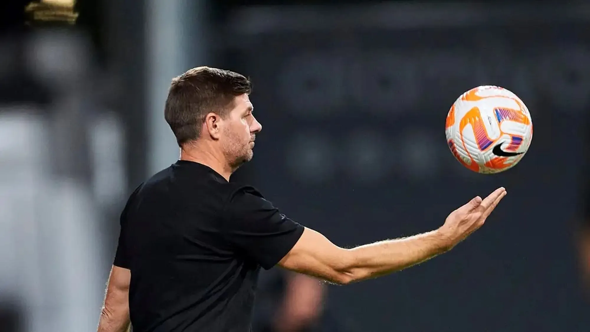 Al Ettifaq’s manager, Steven Gerrard, holding a hovering football.