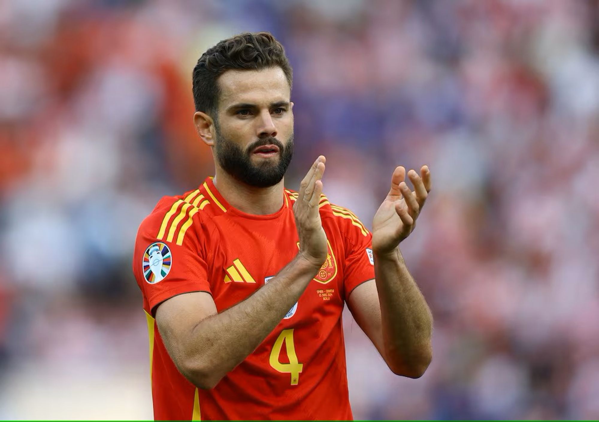 Nacho, Dressed in Spain’s Traditional Red Kit, Claps His Hands in a Past Match.