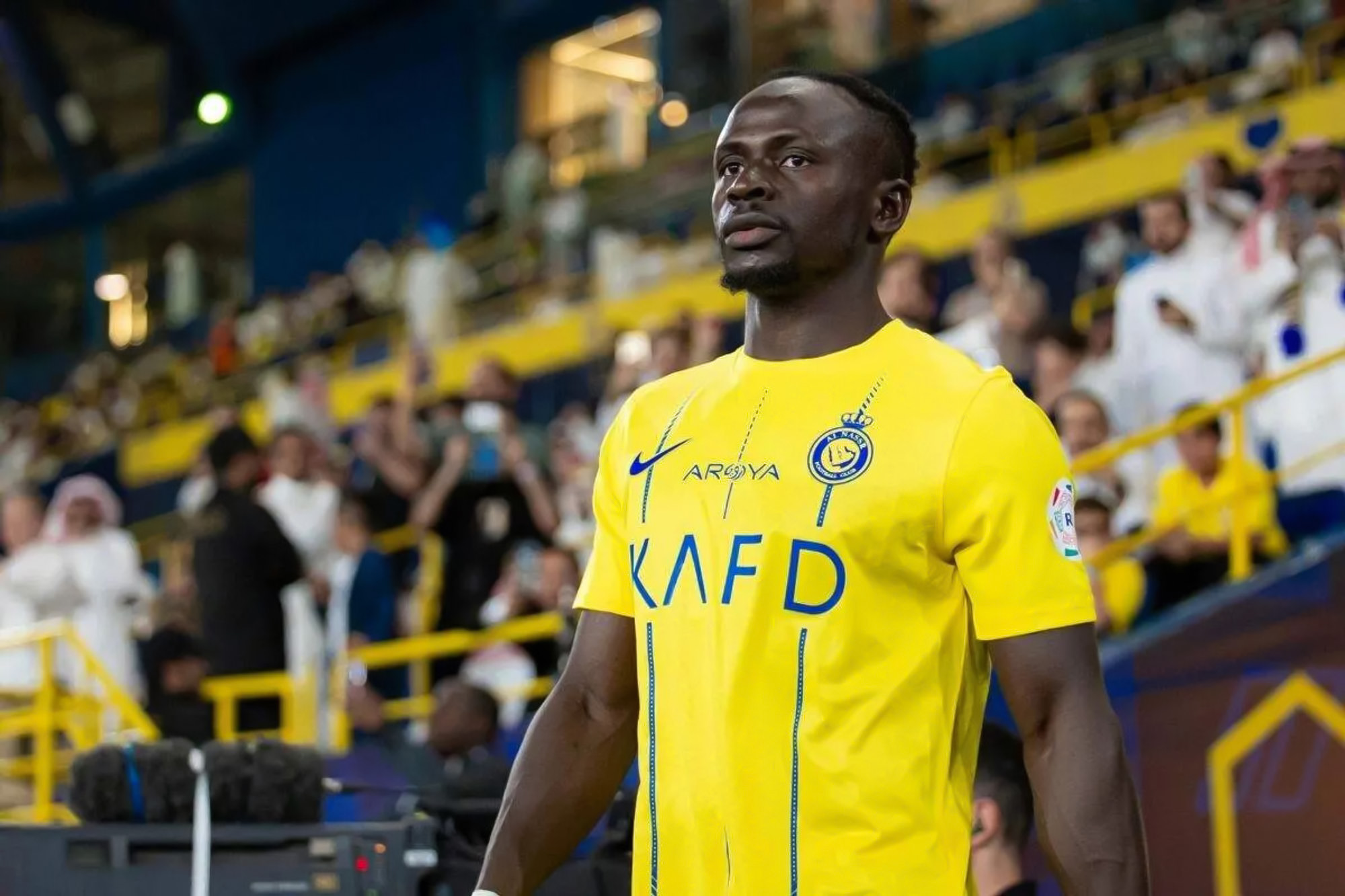 Sadio Mané In Al Nassr's Yellow Jersey Standing on the Sidelines in A Past Match.